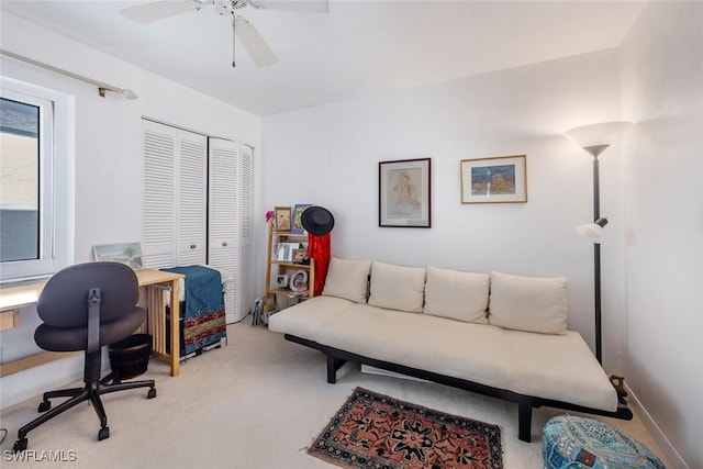 office featuring a ceiling fan, light colored carpet, and baseboards