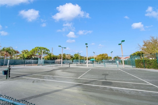 view of tennis court featuring fence