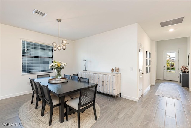 dining area with light wood finished floors, visible vents, and baseboards