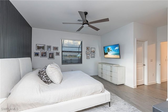 bedroom with ceiling fan, baseboards, and wood finished floors