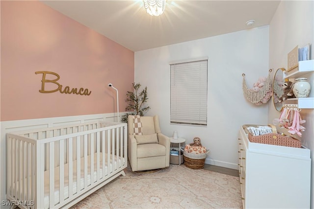 bedroom featuring a crib and baseboards