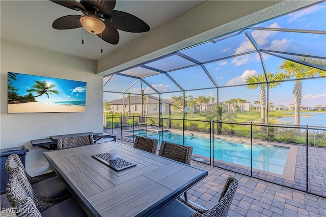 view of patio with outdoor dining space, a lanai, a ceiling fan, and an outdoor pool