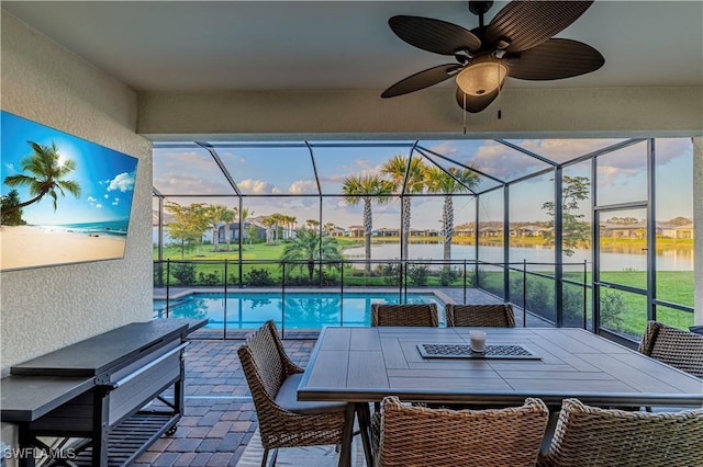 view of patio / terrace with ceiling fan, glass enclosure, a water view, a fenced in pool, and outdoor dining space