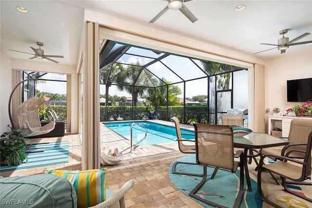 view of swimming pool with a fenced in pool, glass enclosure, a patio area, and a ceiling fan