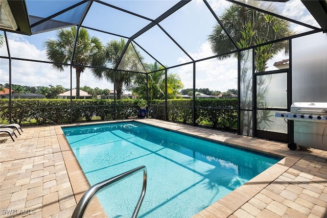 outdoor pool featuring a patio, area for grilling, and a lanai