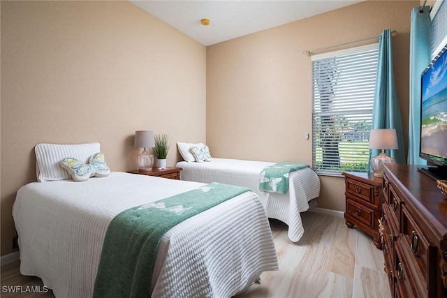 bedroom with light wood finished floors and baseboards