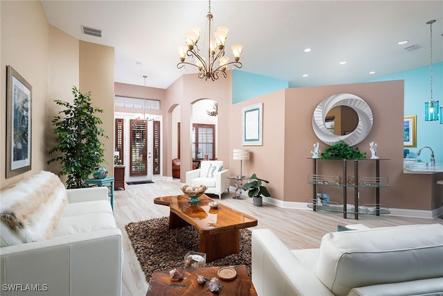 living room featuring a chandelier, recessed lighting, visible vents, and wood finished floors