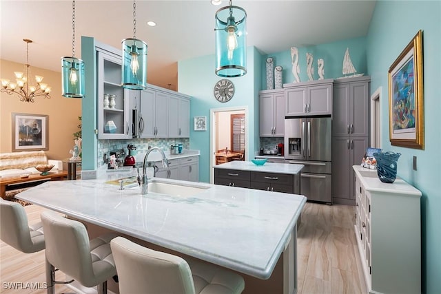 kitchen featuring a kitchen island, stainless steel fridge, backsplash, and gray cabinetry