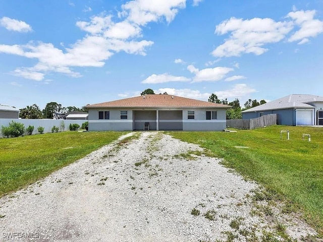 back of property featuring a yard, fence, a sunroom, and stucco siding