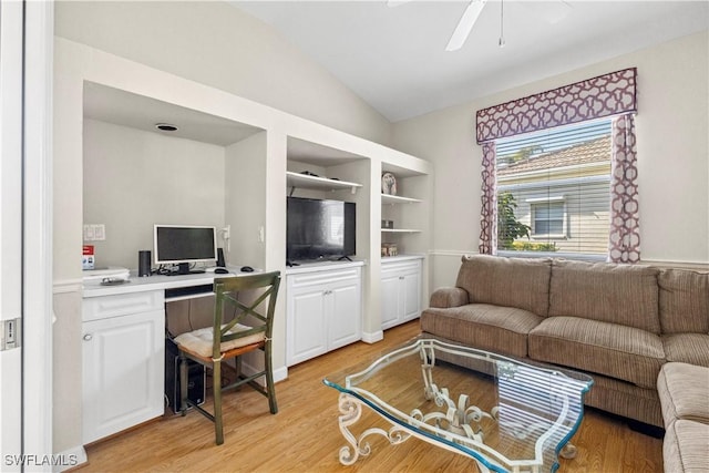 living room with light wood-style floors, built in study area, vaulted ceiling, and a ceiling fan