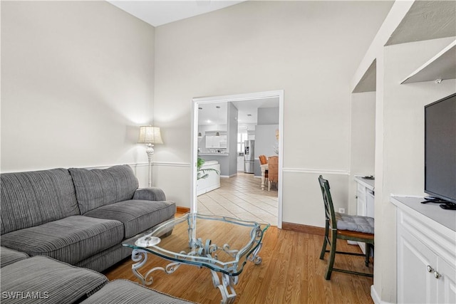 living area featuring light wood-style flooring and baseboards