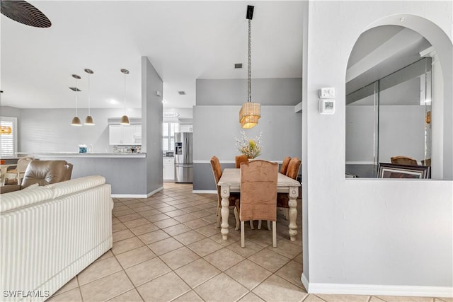 dining room featuring baseboards and light tile patterned floors