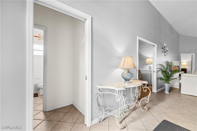 corridor with baseboards and tile patterned floors