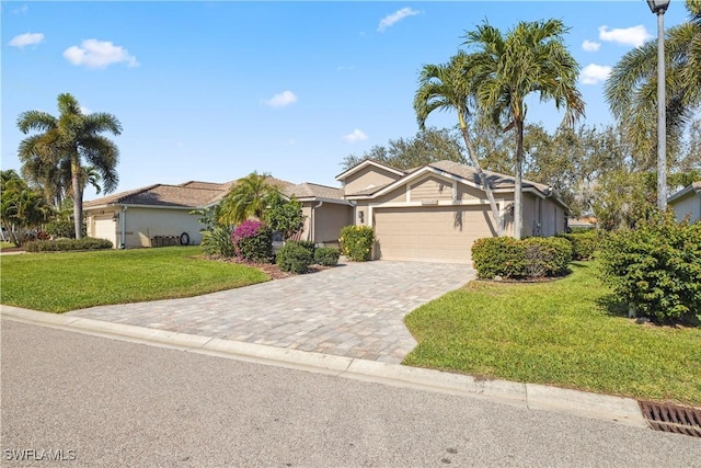 view of front of house featuring an attached garage, a front lawn, and decorative driveway