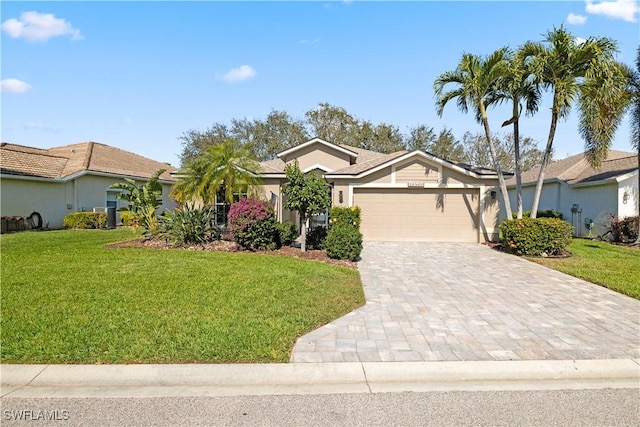 single story home with a garage, a front lawn, decorative driveway, and stucco siding