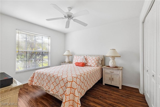 bedroom with dark wood-style floors, ceiling fan, baseboards, and a closet