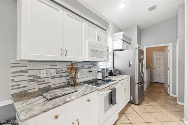 kitchen with white appliances, tasteful backsplash, visible vents, white cabinetry, and separate washer and dryer