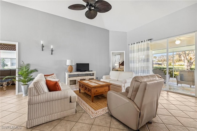 living area featuring ceiling fan, a high ceiling, and light tile patterned floors