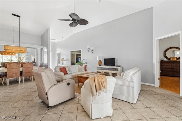 living area featuring light tile patterned floors, ceiling fan, and high vaulted ceiling