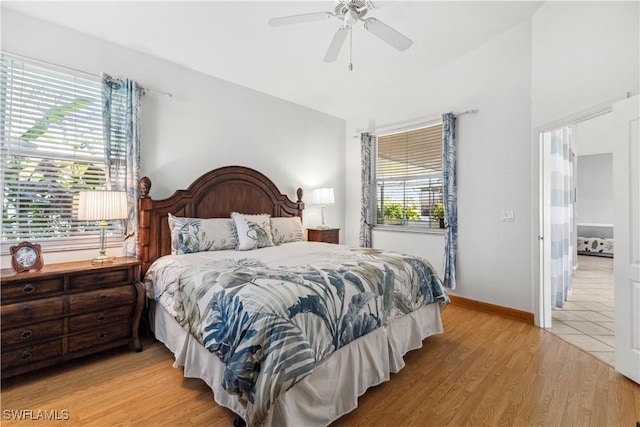 bedroom with a ceiling fan, light wood-style flooring, and baseboards