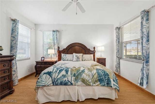 bedroom with light wood-style floors, baseboards, and a ceiling fan