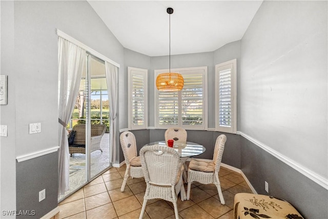 tiled dining area with baseboards and a wealth of natural light