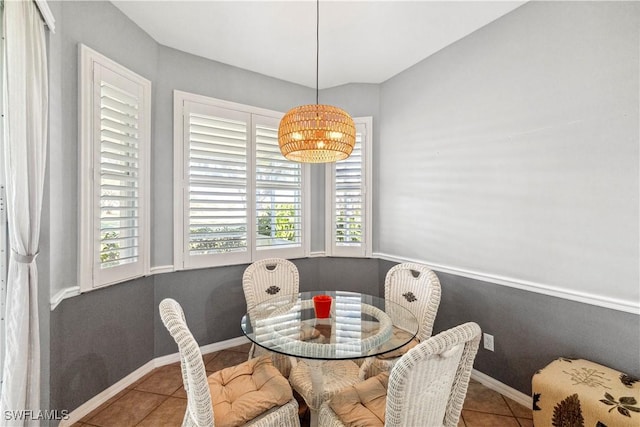 tiled dining space featuring a healthy amount of sunlight and baseboards