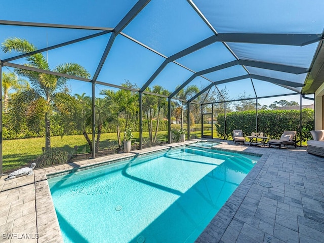 view of swimming pool featuring a lawn, a patio area, a lanai, and a pool with connected hot tub