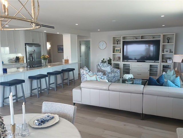 living area featuring light wood finished floors and recessed lighting