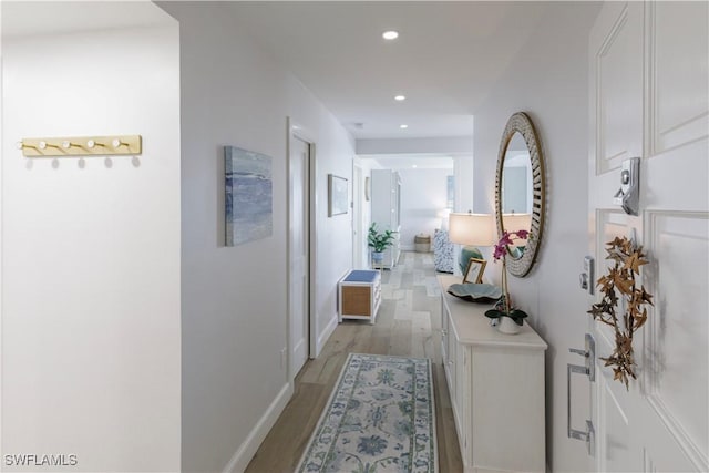 corridor featuring recessed lighting, light wood-style floors, and baseboards