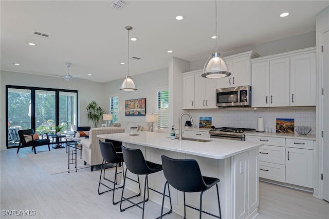 kitchen with stainless steel appliances, backsplash, visible vents, and a healthy amount of sunlight