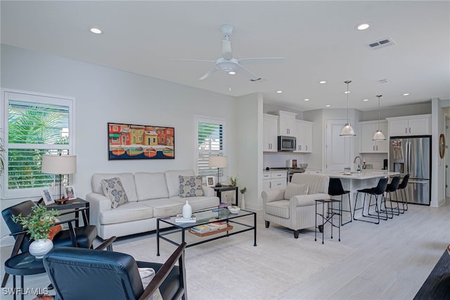 living area featuring light wood finished floors, visible vents, a ceiling fan, and recessed lighting