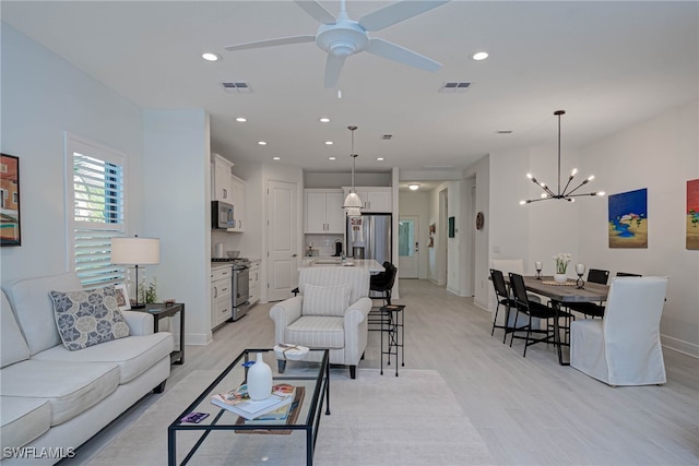 living area with recessed lighting, visible vents, and light wood-style floors