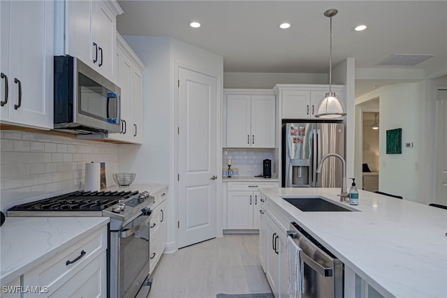 kitchen with white cabinets, visible vents, stainless steel appliances, and a sink