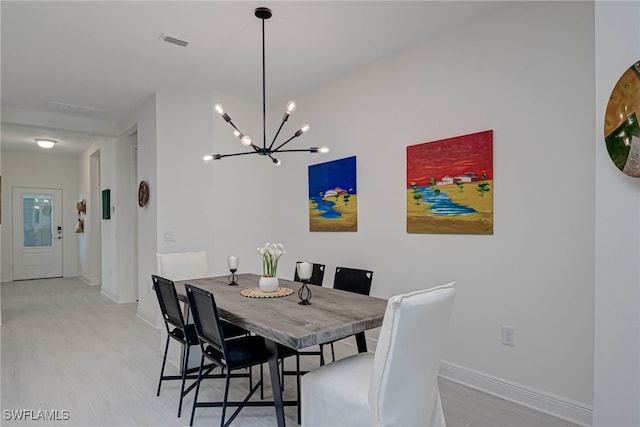 dining space with light wood-type flooring, visible vents, and baseboards