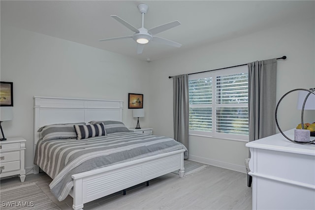 bedroom with a ceiling fan, light wood-type flooring, and baseboards