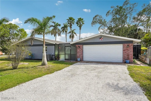 view of front of home featuring driveway, a garage, central AC unit, a front lawn, and brick siding