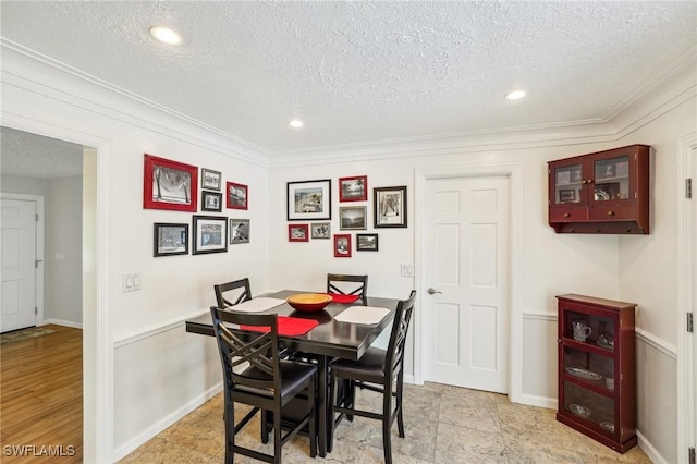 dining room with crown molding, baseboards, a textured ceiling, and recessed lighting