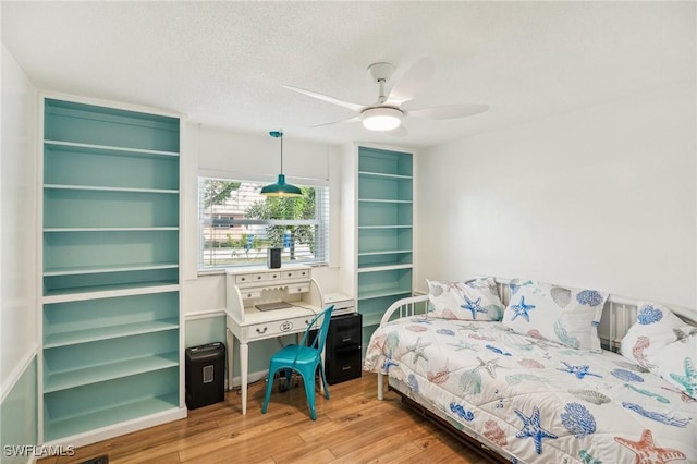 bedroom with ceiling fan, light wood-style flooring, and a textured ceiling