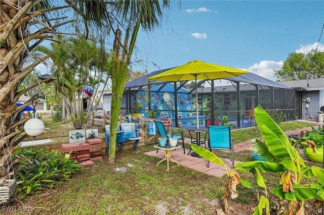 view of play area with glass enclosure, an outdoor pool, and a patio