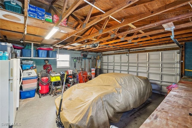 garage with freestanding refrigerator and a garage door opener