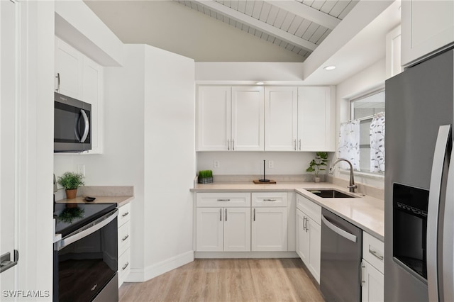 kitchen with appliances with stainless steel finishes, light countertops, white cabinets, and a sink