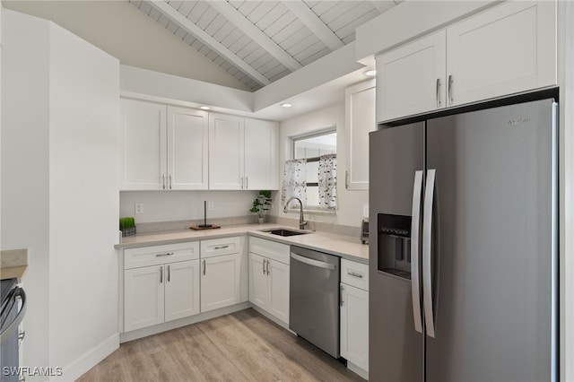 kitchen featuring white cabinets, stainless steel appliances, a sink, and light countertops