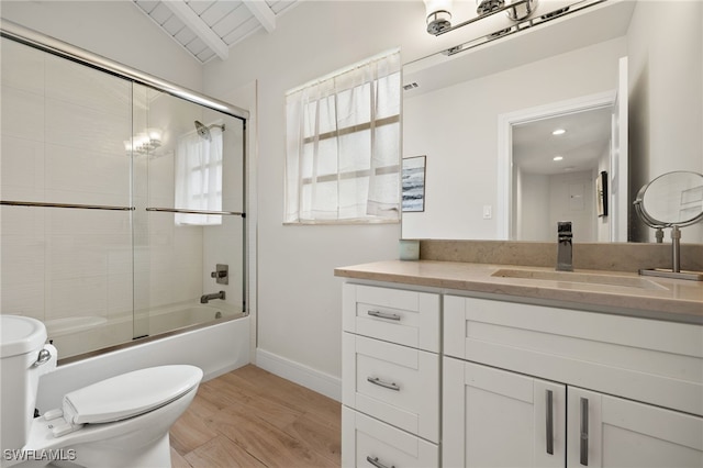 bathroom featuring enclosed tub / shower combo, toilet, wood finished floors, vanity, and baseboards