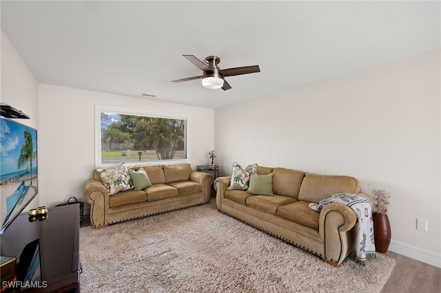 living area featuring baseboards, wood finished floors, visible vents, and a ceiling fan