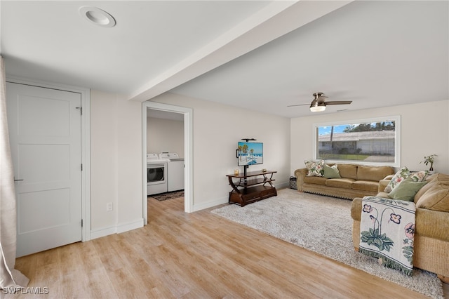 living area featuring light wood-type flooring, baseboards, washer and clothes dryer, and a ceiling fan