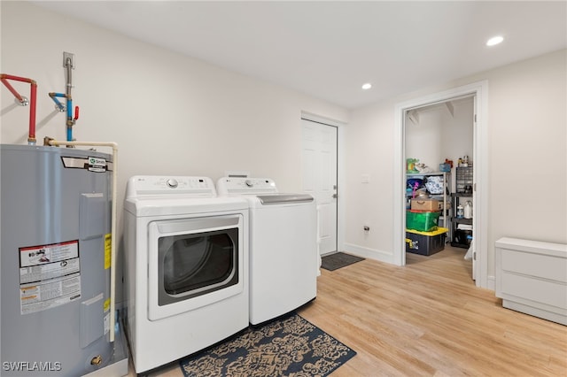 laundry room with washer and clothes dryer, recessed lighting, light wood-style flooring, electric water heater, and laundry area