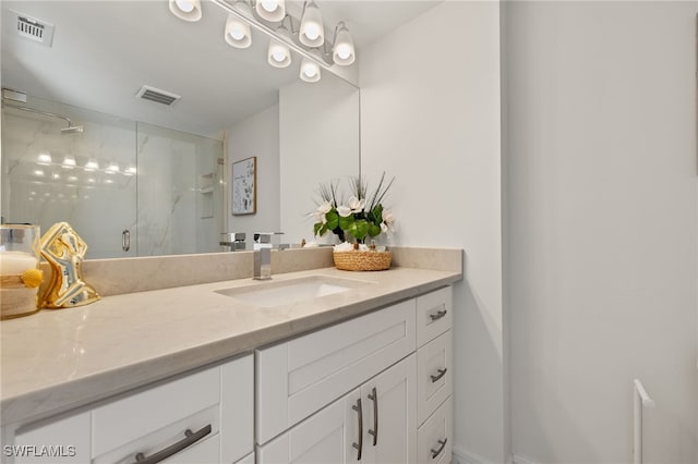 full bath featuring visible vents, vanity, and a marble finish shower