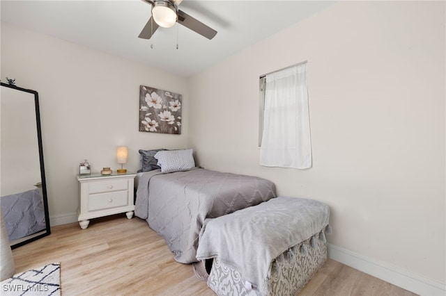 bedroom with light wood-type flooring, ceiling fan, and baseboards