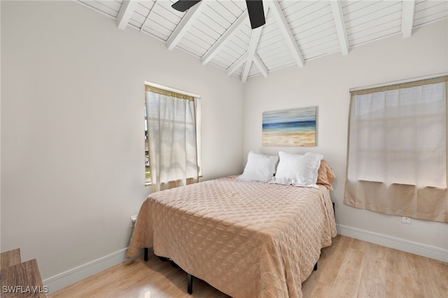 bedroom featuring vaulted ceiling with beams, a ceiling fan, baseboards, and wood finished floors